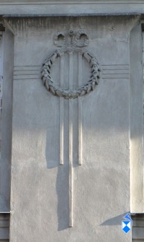 Pionowy pilaster z głowicą z z medalionami z wieńców